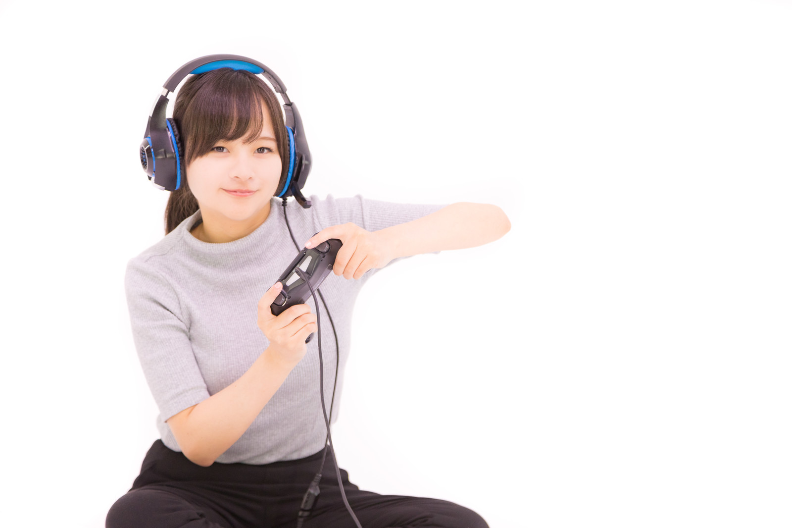 ゲーム用のヘッドフォンをして本格的にオンラインゲームを楽しんでいる可愛い女の子のイメージ画像